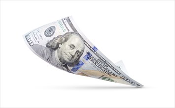 One hundred dollar bill floating down to surface with drop shadow isolated on a white background