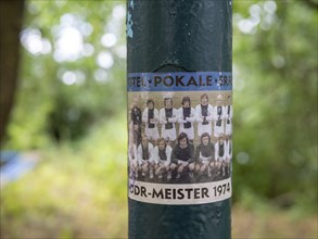 Sticker with the photo of the football team 1. FC Magdeburg, GDR champion 1974, on a lamppost at