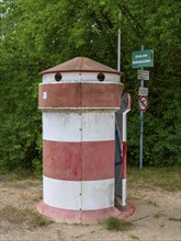 Old round red-white-ringed changing room from GDR times in the shape of a lighthouse on the shore