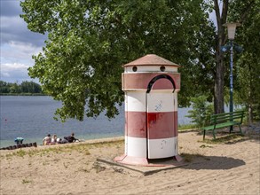 Old round red-white-ringed changing room from GDR times in the shape of a lighthouse on the shore