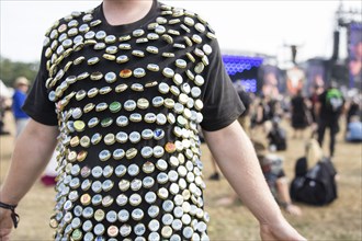 A festival visitor has decorated his shirt with bottle caps at the Wacken Open Air in Wacken. The