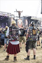 Metalheads with patches in front of the main stages at the Wacken Open Air in Wacken. The