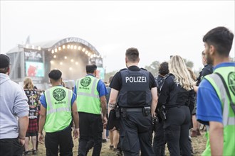 Police officers and metal guards in front of the Louder stage at the Wacken Open Air in Wacken. The