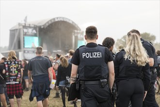 Policemen in front of the Louder stage at the Wacken Open Air in Wacken. The traditional metal