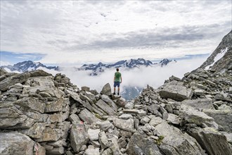 Mountaineer in a rocky saddle, Lapenscharte with view of mountain peaks, Berliner Höhenweg,