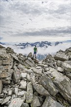 Mountaineer in a rocky saddle, Lapenscharte with view of mountain peaks, Berliner Höhenweg,