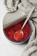 Tin can, with red caviar and a spoon, imitation, top view, right above, no people