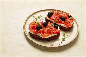 Sandwiches with red fish, cream cheese, olives and microgreens, breakfast