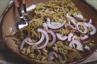 Jonjoli, Colchian klekachka, jonjoli salad, with red onion and butter, Georgian appetizer, pickled