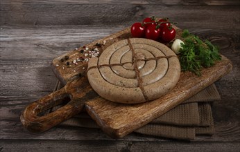 Raw spiral sausages, on a wooden board, top view, no people