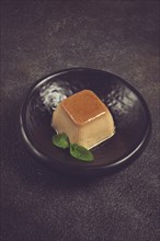 Cream caramel pudding, with caramel sauce, dessert, breakfast, on a black plate, mint, no people