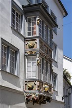 Artfully decorated bay window, stonemasonry work on a historic town house in the monastery quarter,