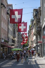 The Multergasse, pedestrian zone, shopping alleyway, decorated with Swiss national flags in the