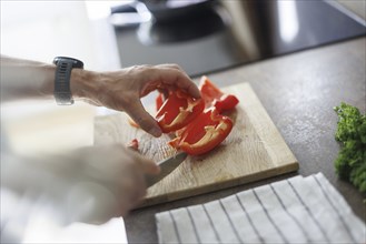 Cooking topic. A man cuts a sweet pepper. Berlin, 01.08.2024