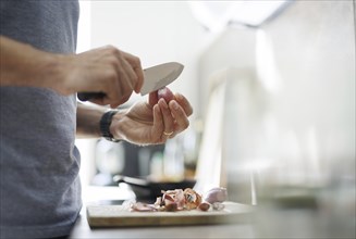 Cooking topic. A man peels an onion. Berlin, 01.08.2024