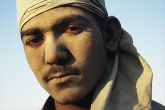 Portrait of a man loading sacks of gypsum in a train India