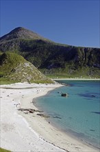 A picturesque beach with blue sea and people, surrounded by green mountains, Haukland, Leknes,