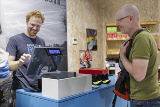 Sporting goods sales, retail purchase, Bonn, 31.07.2024. Customer and cashier paying