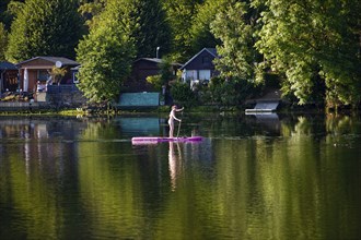 Panorama Hengsteysee with stand-up paddler in front of allotment gardens on the shore, Hagen, North