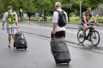 Tourists with wheeled suitcases