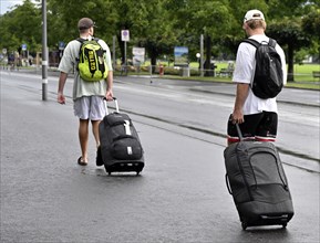 Tourists with wheeled suitcases