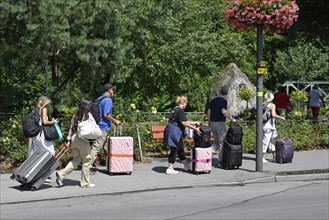 Tourists with wheeled suitcases