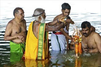 Head priest Siva Sri Arumugam Paskarakurukkal in the Datteln-Hamm canal during ritual purification,