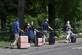 Tourists with wheeled suitcases