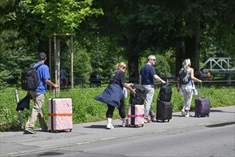 Tourists with wheeled suitcases