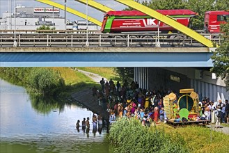 Heavy goods traffic on the A 2 motorway with Hindus under the motorway bridge on and in the