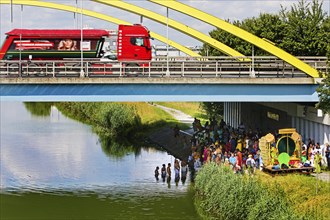 Heavy goods traffic on the A 2 motorway with Hindus under the motorway bridge on and in the