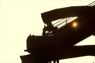 The sun shines through large former industrial pipes in the Westpark with a pigeon, industrial