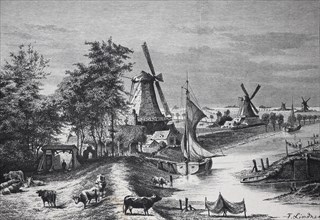 Windmills and boats by a river in an idyllic rural landscape with people and animals, Holland,