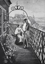 Couple standing on a balcony of the tower guard. A view of the city can be seen in the background,