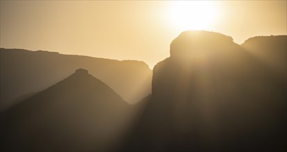 Light mood at sunrise at the Blyde River Canyon, sun rises behind a mountain peak, canyon landscape