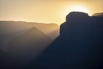 Light mood at sunrise at the Blyde River Canyon, sun rises behind a mountain peak, canyon landscape