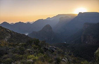 Light mood at sunrise at the Blyde River Canyon, sun rises behind a mountain peak, canyon landscape