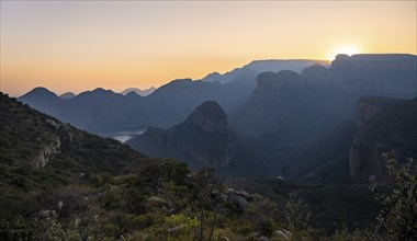 Light mood at sunrise at the Blyde River Canyon, sun rises behind a mountain peak, canyon landscape