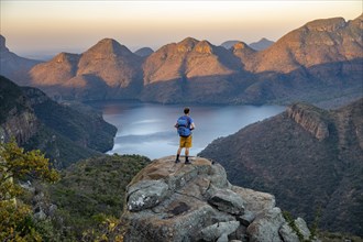 Young man standing on rocks and enjoying the view, Sunset at Blyde River Canyon View of canyon with