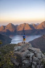 Young man standing on rocks and enjoying the view, Sunset at Blyde River Canyon View of canyon with