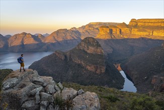 Young man standing on rocks and enjoying the view, sunset at Blyde River Canyon with Three