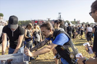 Festival visitors refresh themselves at the Wacken Open Air in Wacken. The traditional metal