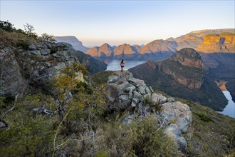 Young woman standing on rocks and enjoying the view, sunset at Blyde River Canyon with Three