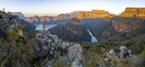 Young woman standing on rocks and enjoying the view, sunset at Blyde River Canyon with Three