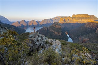 Young woman standing on rocks and enjoying the view, sunset at Blyde River Canyon with Three