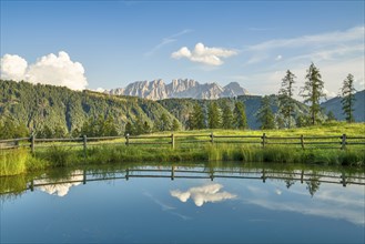 Mountains reflected in a small mountain lake, blue sky with clouds, Wuhnleger Weiher, Dolomites,