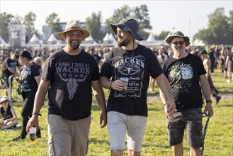 Festival visitors with Wacken T-shirts at the Wacken Open Air in Wacken. The traditional metal