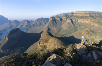 Tourist standing on a rock and enjoying the view of the canyon, Blyde River Canyon with Three