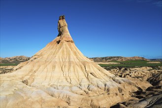 Striking rock formations rise up in an arid landscape under a deep blue sky, Castildetierra,