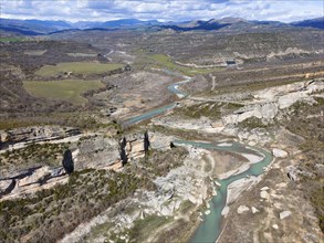 Aerial view of a stunning mountain landscape with steep rock faces and a river meandering through